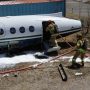Pompiers qui arrose l'avion avec leur lance.